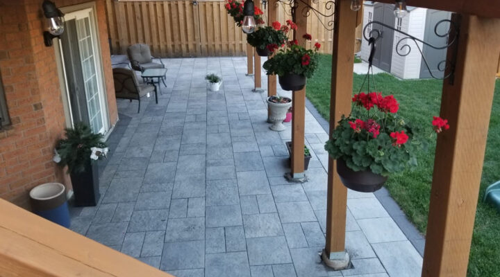 Landscaping Toronto - A patio with a wooden deck and flower pots.