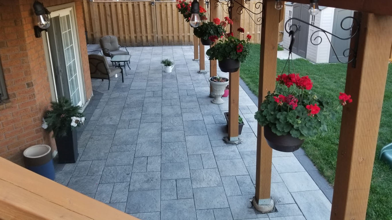 Landscaping Toronto - A patio with a wooden deck and flower pots.
