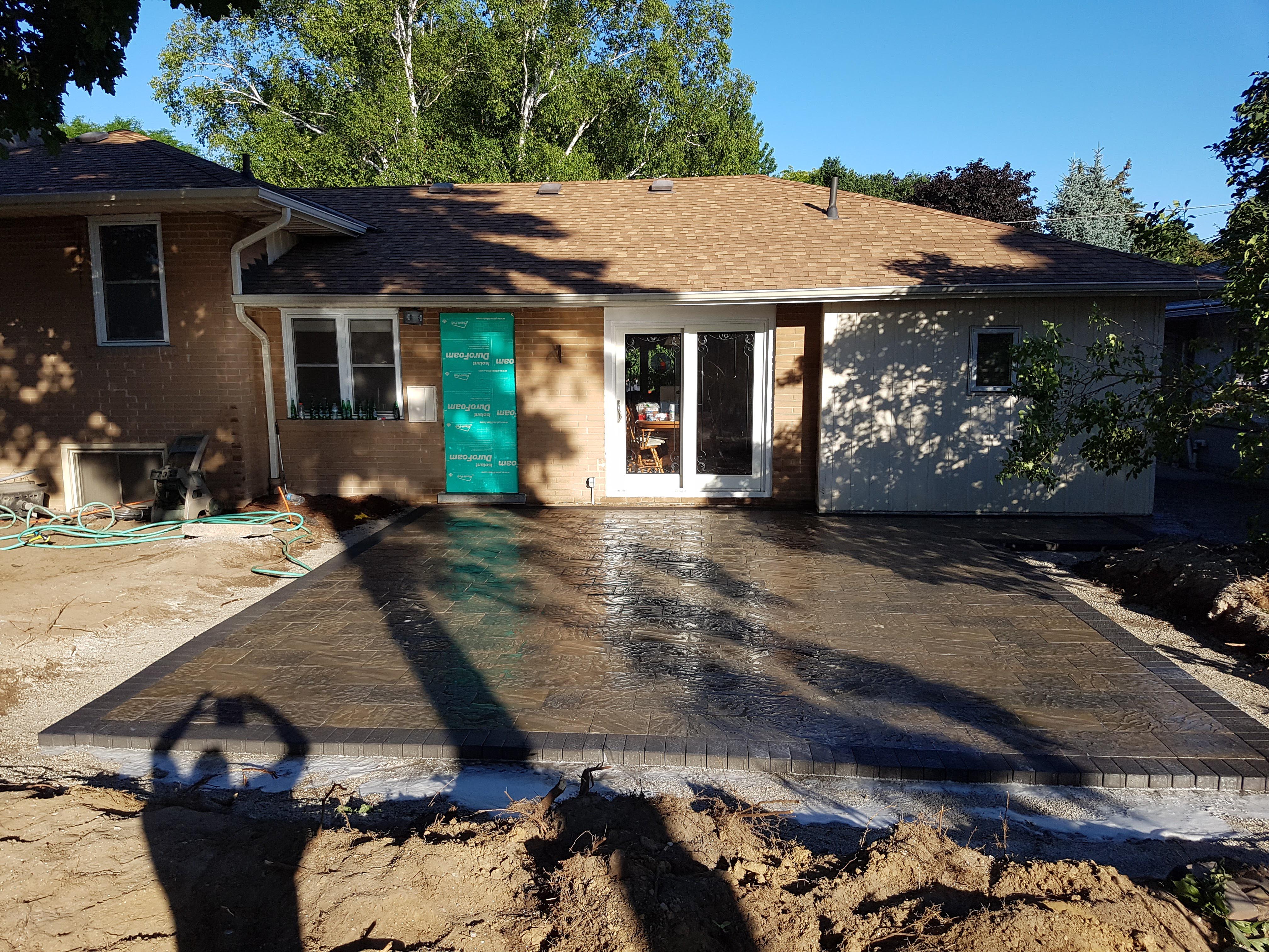 Landscaping Toronto - A Terrastone Landscaping concrete patio is being built in front of a house.