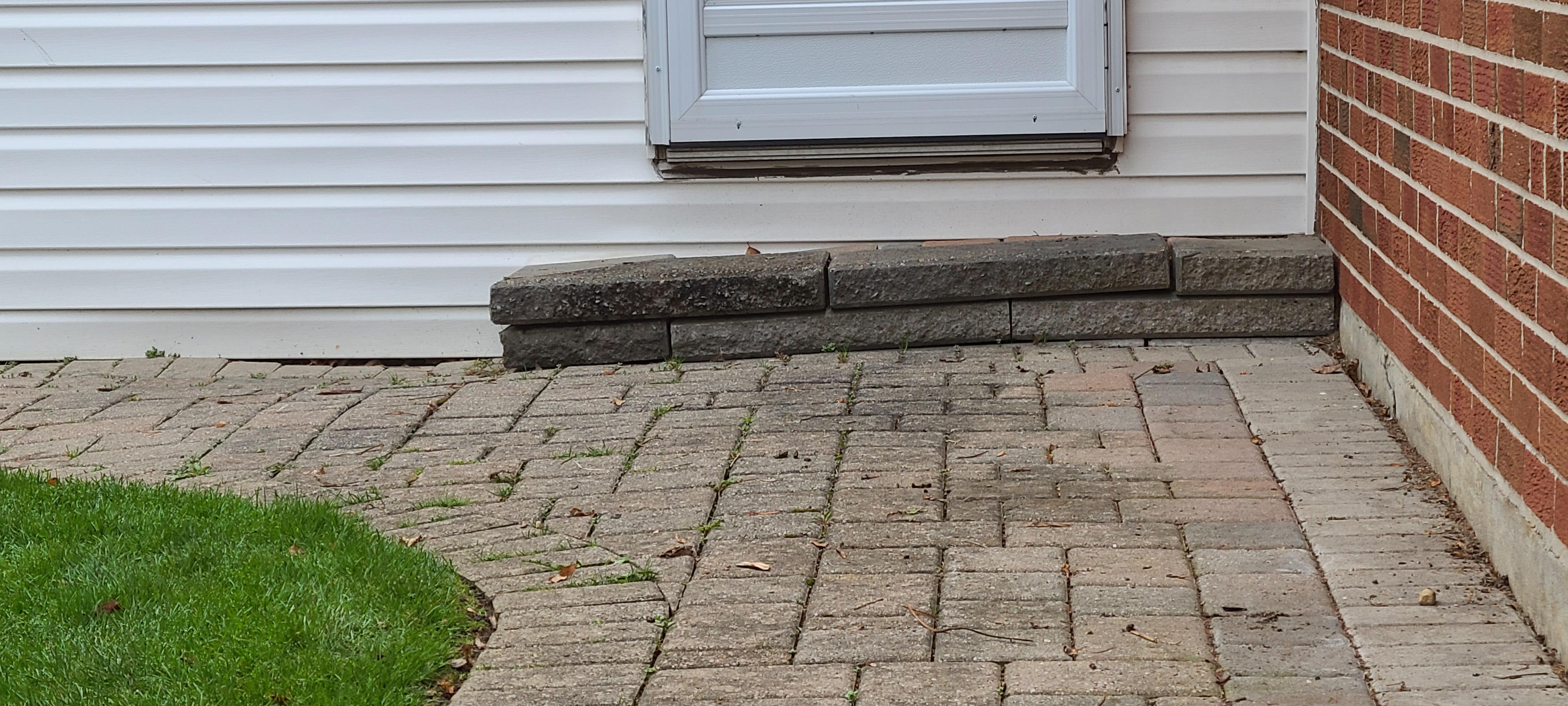 Landscaping Toronto - A Terrastone Landscaping brick walkway next to a house with a door.