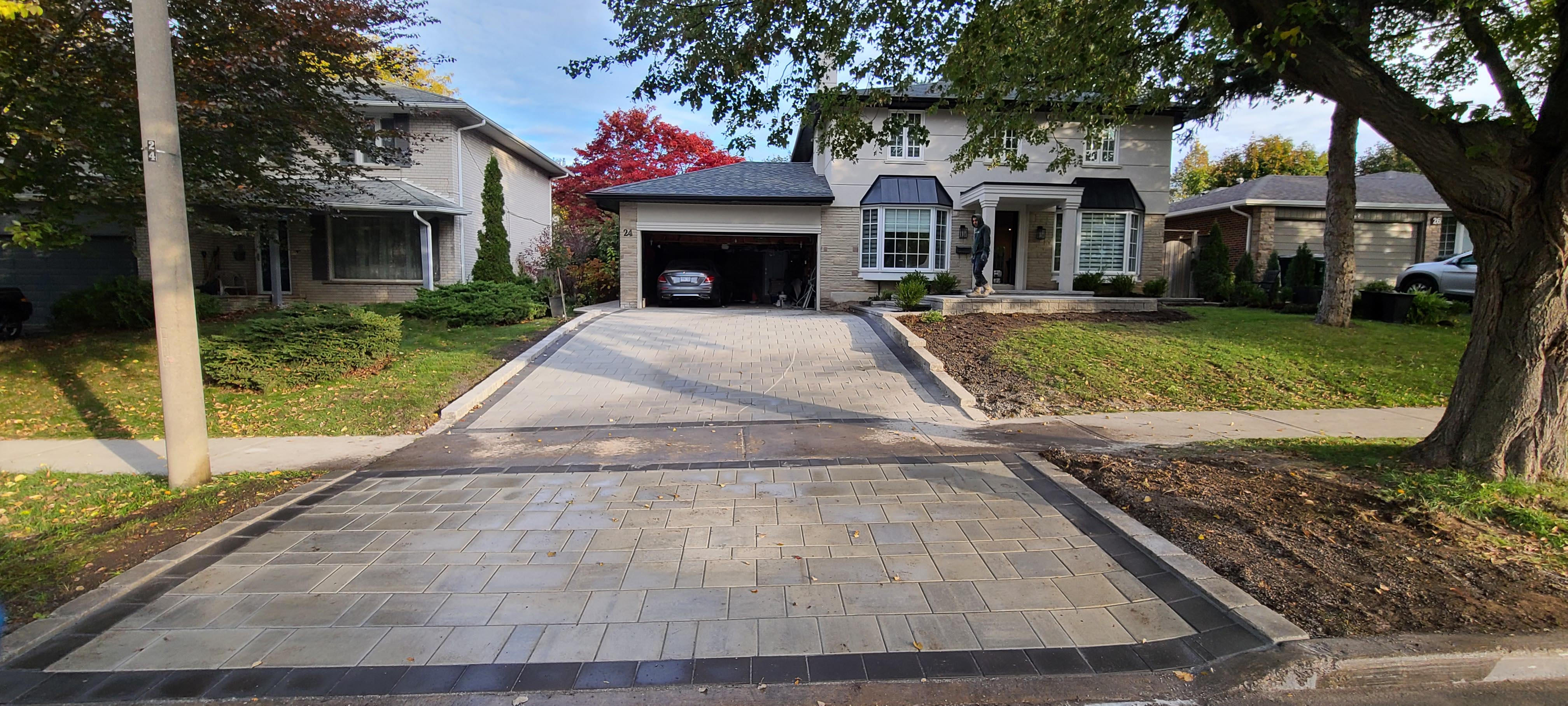 Landscaping Toronto - A Terrastone Landscaping-designed driveway in a residential area with a car parked on it.