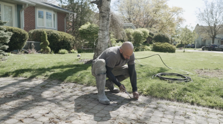 Landscaping Toronto - A man power washing a lawn.