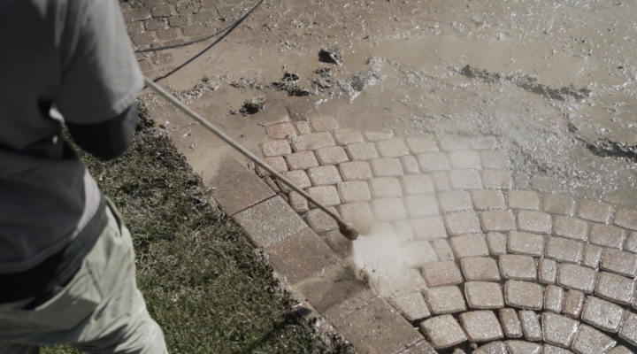 Landscaping Toronto - A man is power washing a brick paver.