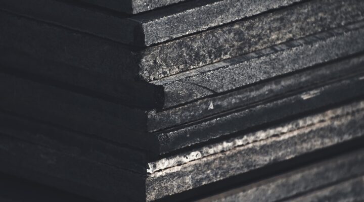 Landscaping Toronto - Close-up of a stack of weathered black slate stone tiles showing textures and edges.